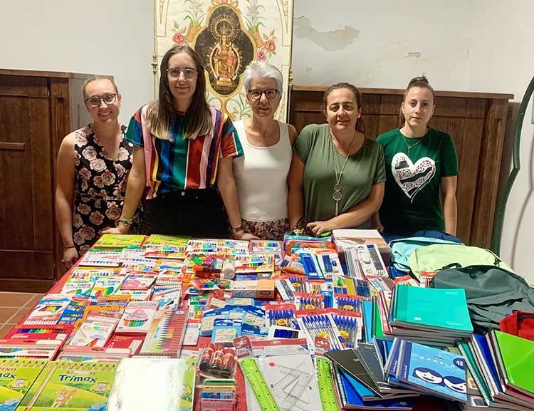 Integrantes de la Hermandad Virgen de la Antigua, con el material escolar recogido.