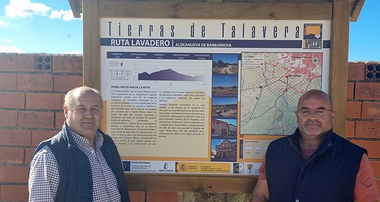 José Manuel Fernández (i), alcalde de Aldeanueva, ante el cartel de inicio de sendero junto al presidente de ADC, Víctor Elvira.